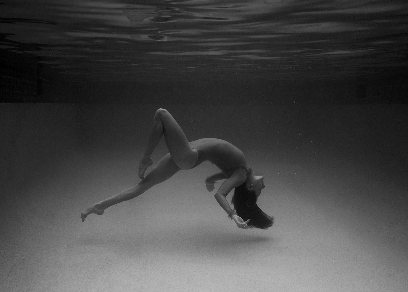 A woman in a bathing suit gracefully glides underwater, captured in "Red Head Series #9" by Francesca Owen. This stunning visual is printed on fine art paper using archival pigments, ensuring longevity and vibrancy.