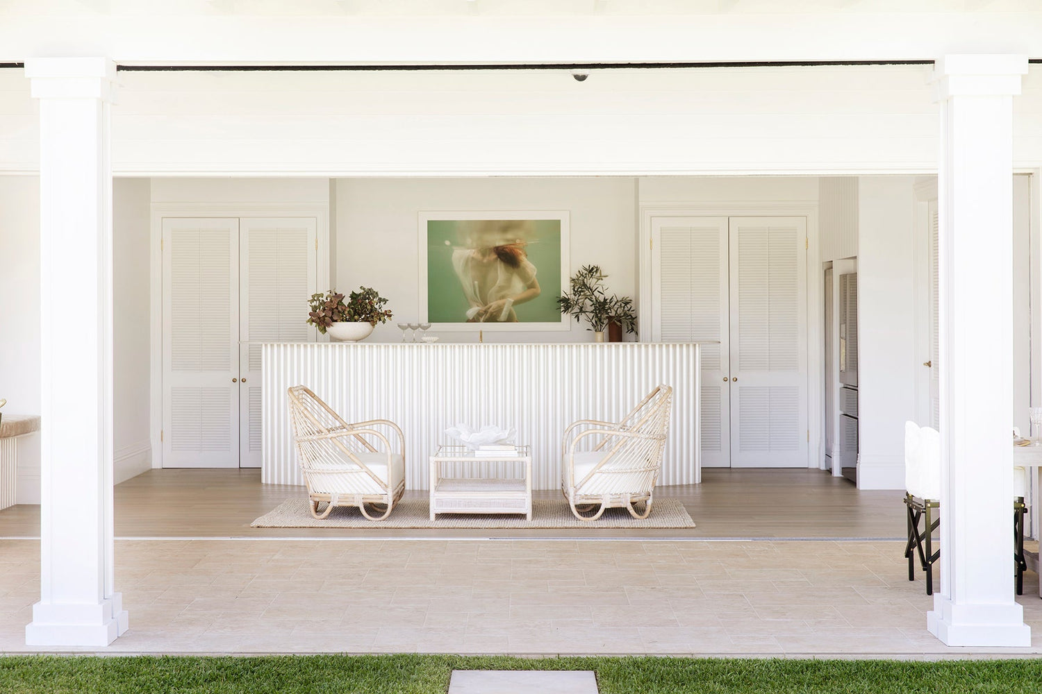 A submerged person in a translucent white shirt, with head above water in a greenish underwater setting. Their hands hold the shirt partially closed.