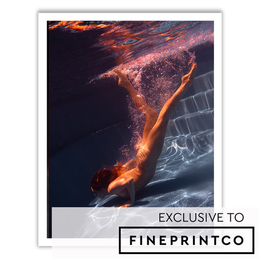 An underwater photograph named "Glisten 03" by Francesca Owen captures a person diving gracefully towards the pool floor. Bubbles and light reflections create dynamic patterns around their body. Printed on fine art paper, the image is framed with a white border, and the label "EXCLUSIVE TO FINEPRINTCO" is at the bottom right corner.