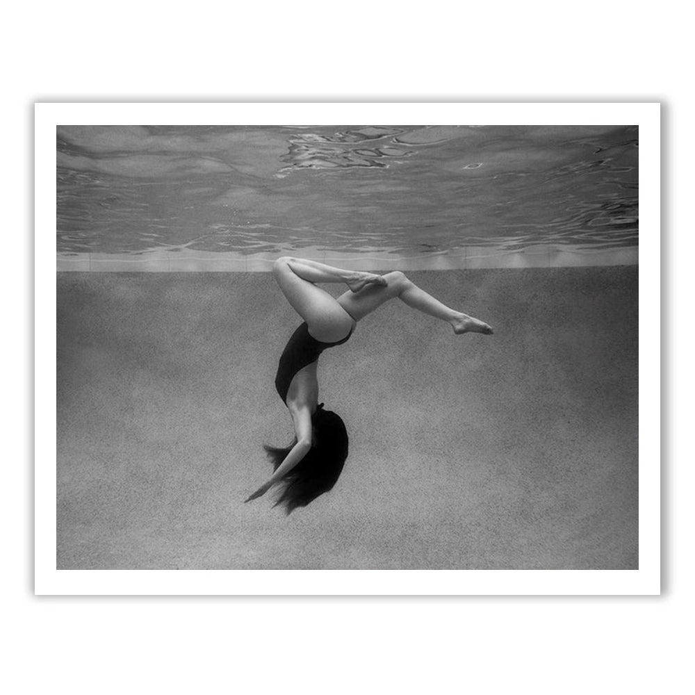A woman in a swimsuit floats upside down underwater, her long hair flowing. "Palm Springs Solo" is a striking black and white fine art print by Francesca Owen, accompanied by a certificate of authenticity.