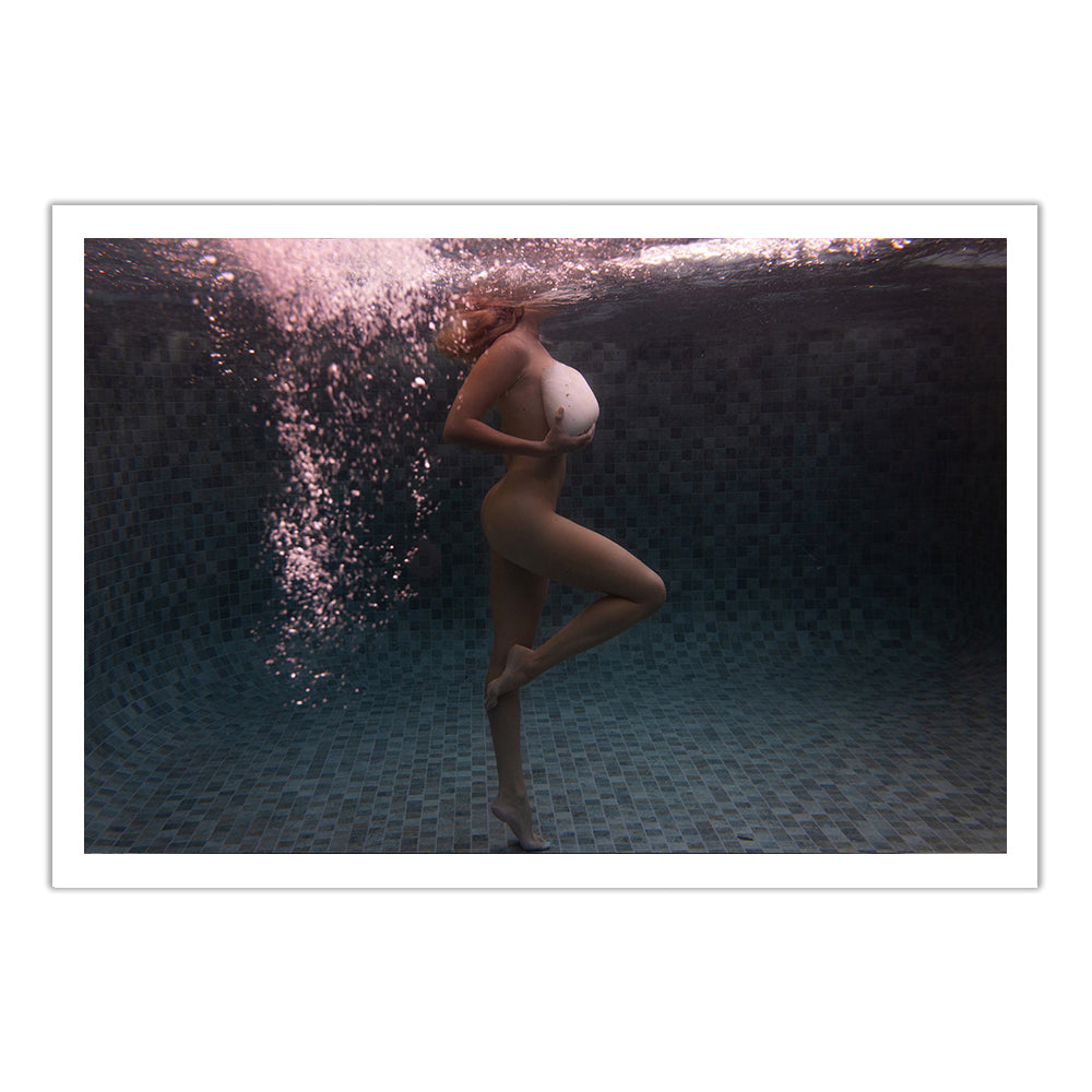 A person stands on one leg underwater in a tiled pool, arm across their chest, with air bubbles rising over their face and soft reflections—captured in Francesca Owen’s Shell & She #1 fine art print with certificate of authenticity.