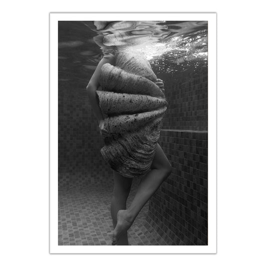 Shell & She #2" by Francesca Owen: a black and white underwater photo featuring a person with a large seashell in a tiled pool, with bubbles and light above. Hand-signed art prints available.