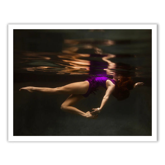 A woman in a purple swimsuit floats underwater in "Show Time Part 2, #1" by Francesca Owen. This tranquil scene is available on fine art paper and comes with a certificate of authenticity.