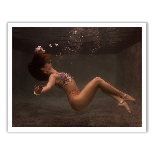 In the distinct style of Francesca Owen, "Show Time Part 3, #3" captures a serene and ethereal moment as a person in a swimsuit gracefully floats underwater amid bubbles, all bathed in soft, brownish light. This exquisite scene is perfect for immortalizing on fine art paper using archival pigments.