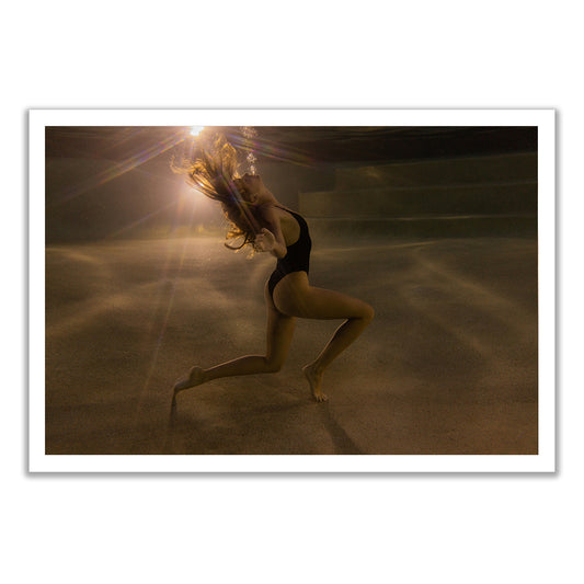 A woman in a black swimsuit poses underwater as sunlight illuminates her and the pool floor in "The Bower #1" by Francesca Owen, offered as hand-signed art prints with a certificate of authenticity.