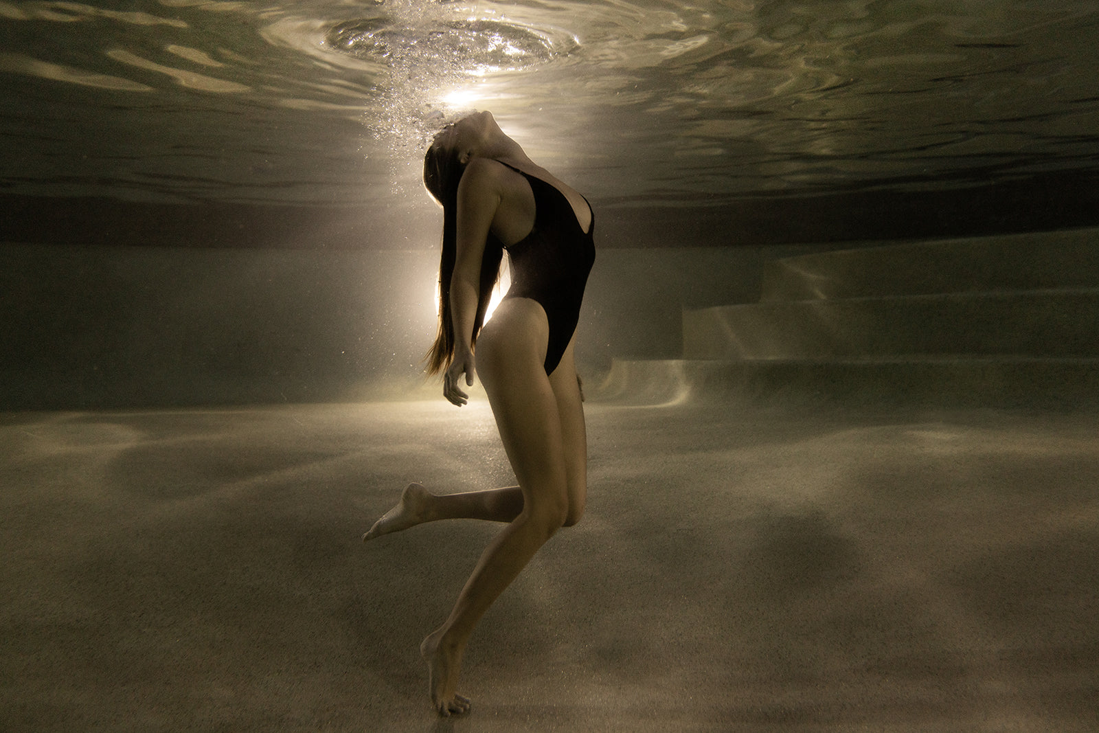 A woman in a black swimsuit poses underwater, her hair flowing near pool steps and bubbles rising. "The Bower #4" by Francesca Owen is available as a fine art print with a certificate of authenticity.