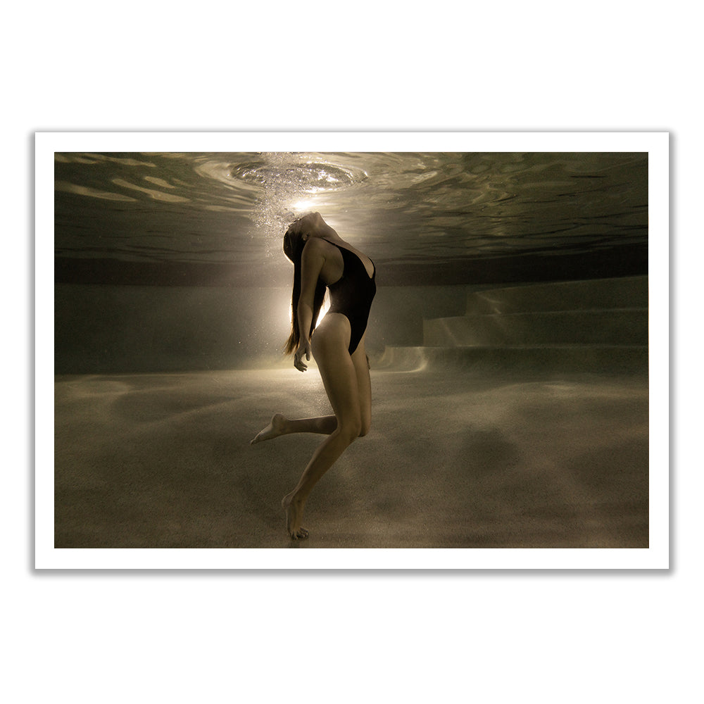 A woman in a black swimsuit arches and tosses her hair underwater, sunlight above—captured in "The Bower #4" by Francesca Owen, available as fine art paper with certificate of authenticity.