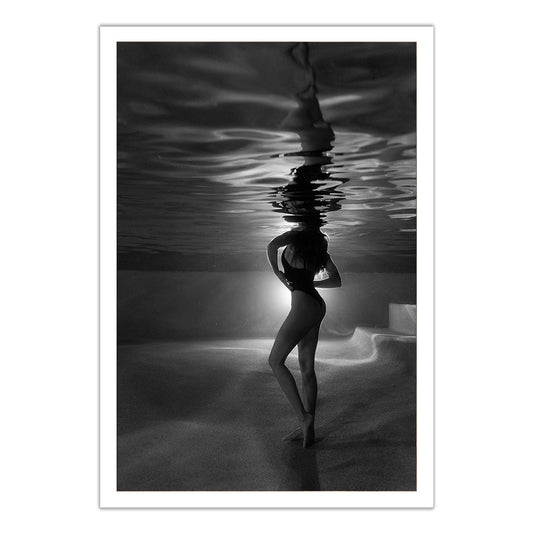 The Bower #6" by Francesca Owen is a black and white photo of a woman standing underwater in a swimsuit, illuminated from behind with her reflection above. Each hand-signed art print includes a certificate of authenticity.